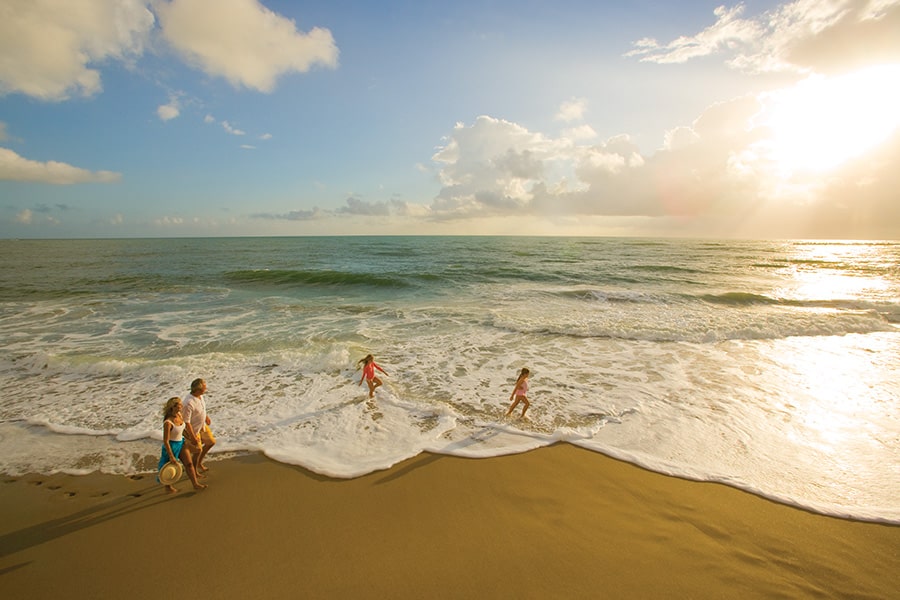 family enjoying a walk on the beach