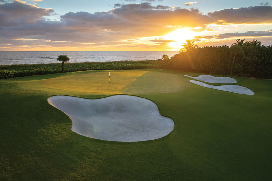 golf course hole overlooking the ocean at sunset