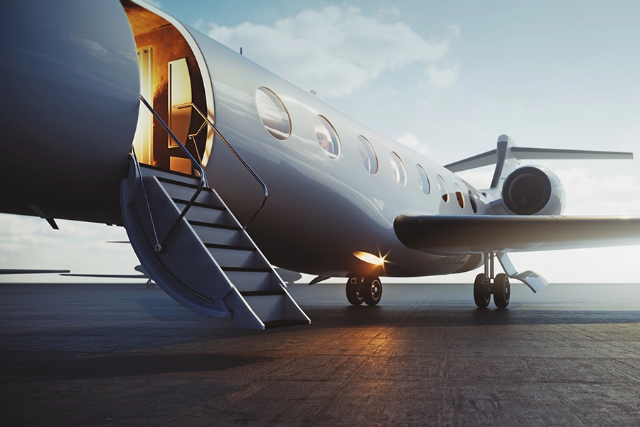 Private jet parked on a runway with boarding stairs
