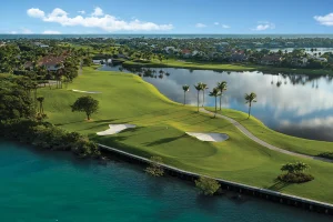 Aerial view of golf course beside waterfront lagoon